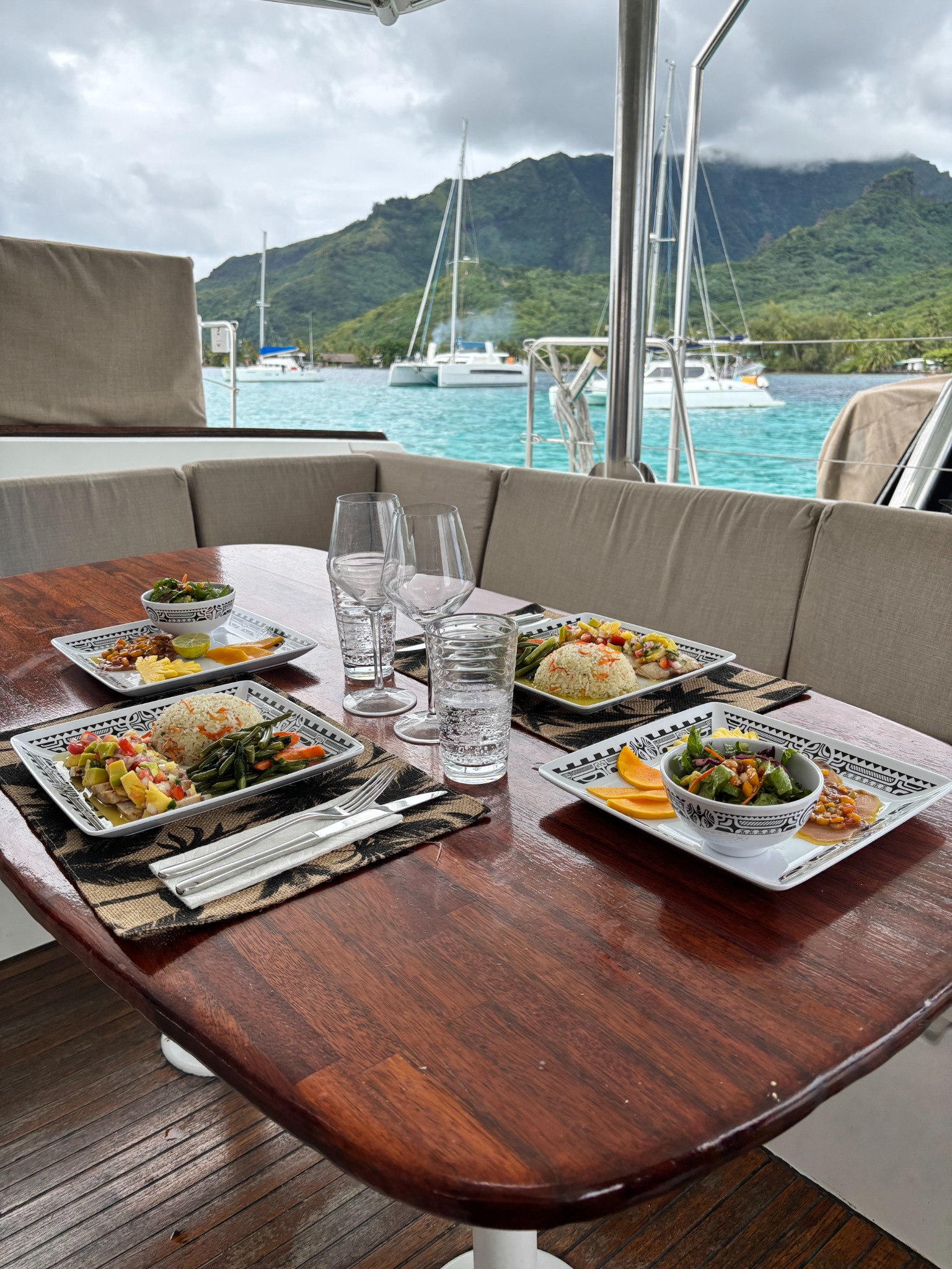 Repas dressés sur la table du catamaran avec vue sur le lagon de Moorea