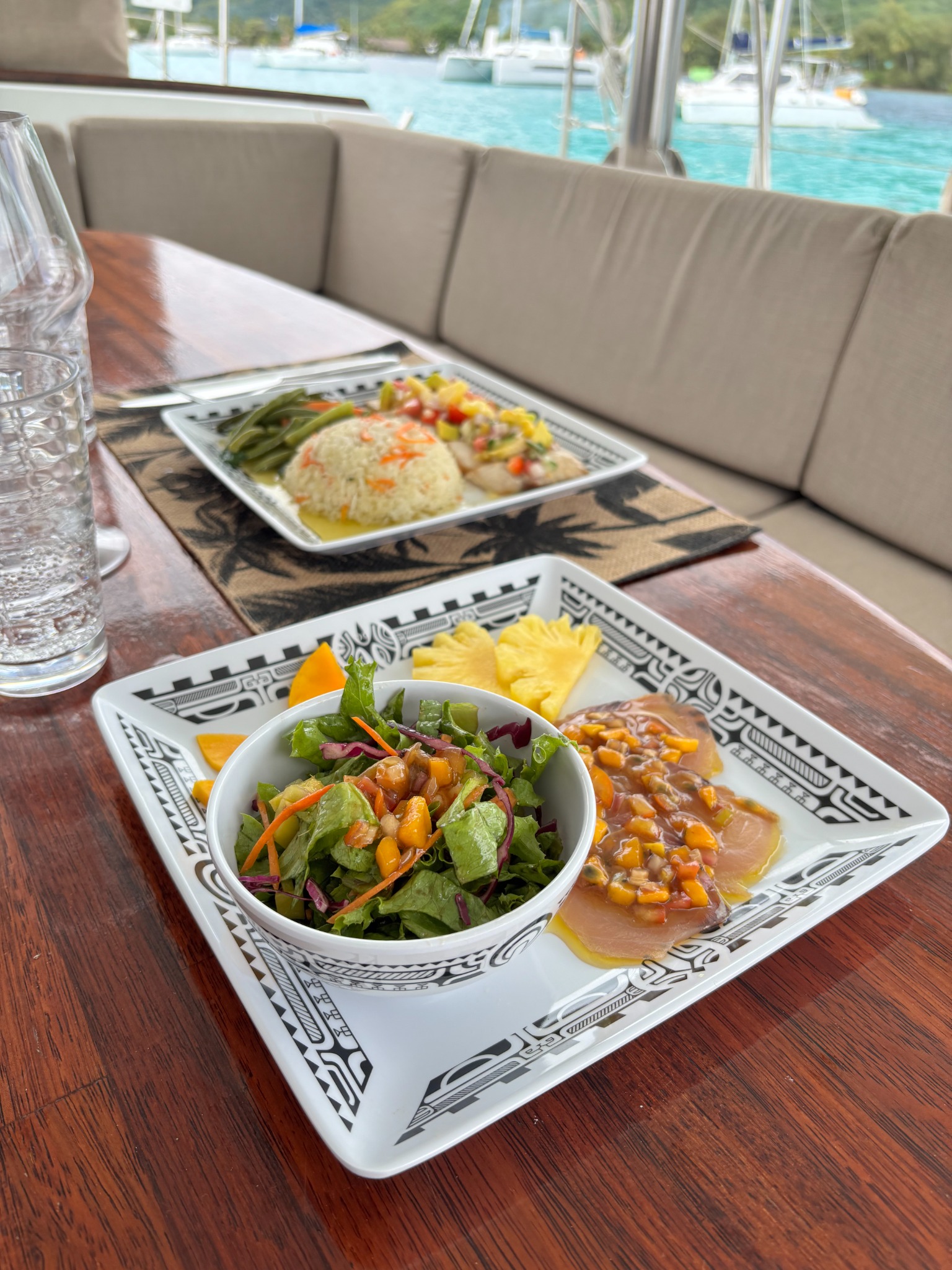 Carpaccio de poisson et fruits tropicaux servis à bord du catamaran