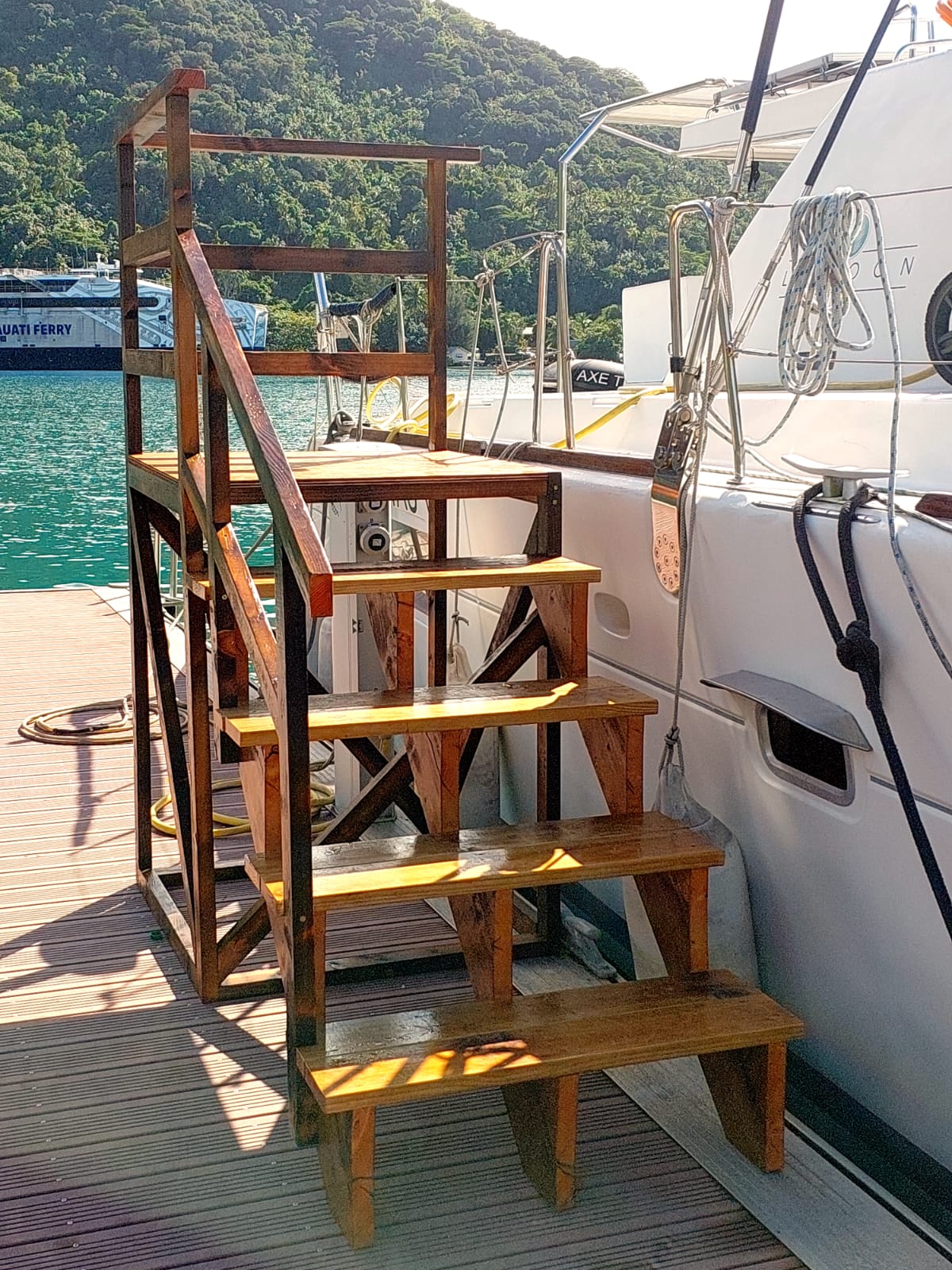 Marches d’embarquement en bois avec main courante entre le ponton de la marina et TUATAU V