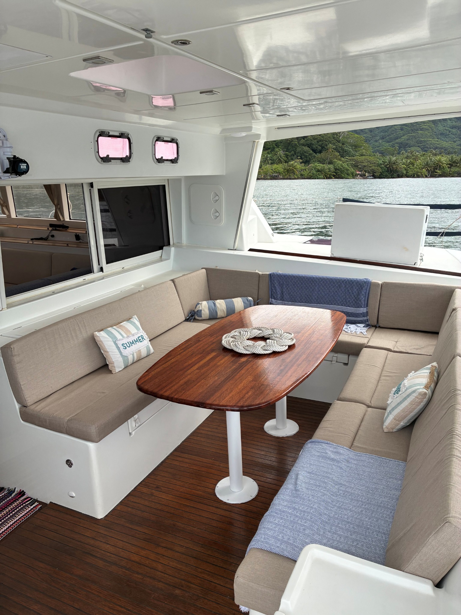 Table et banquettes du cockpit ombragé à bord de TUATAU V