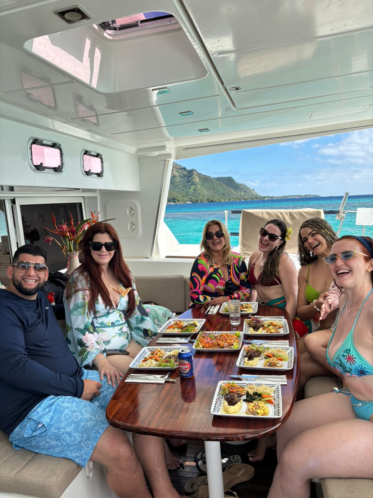 Amis partageant un déjeuner à bord de TUATAU V face au lagon turquoise de Moorea