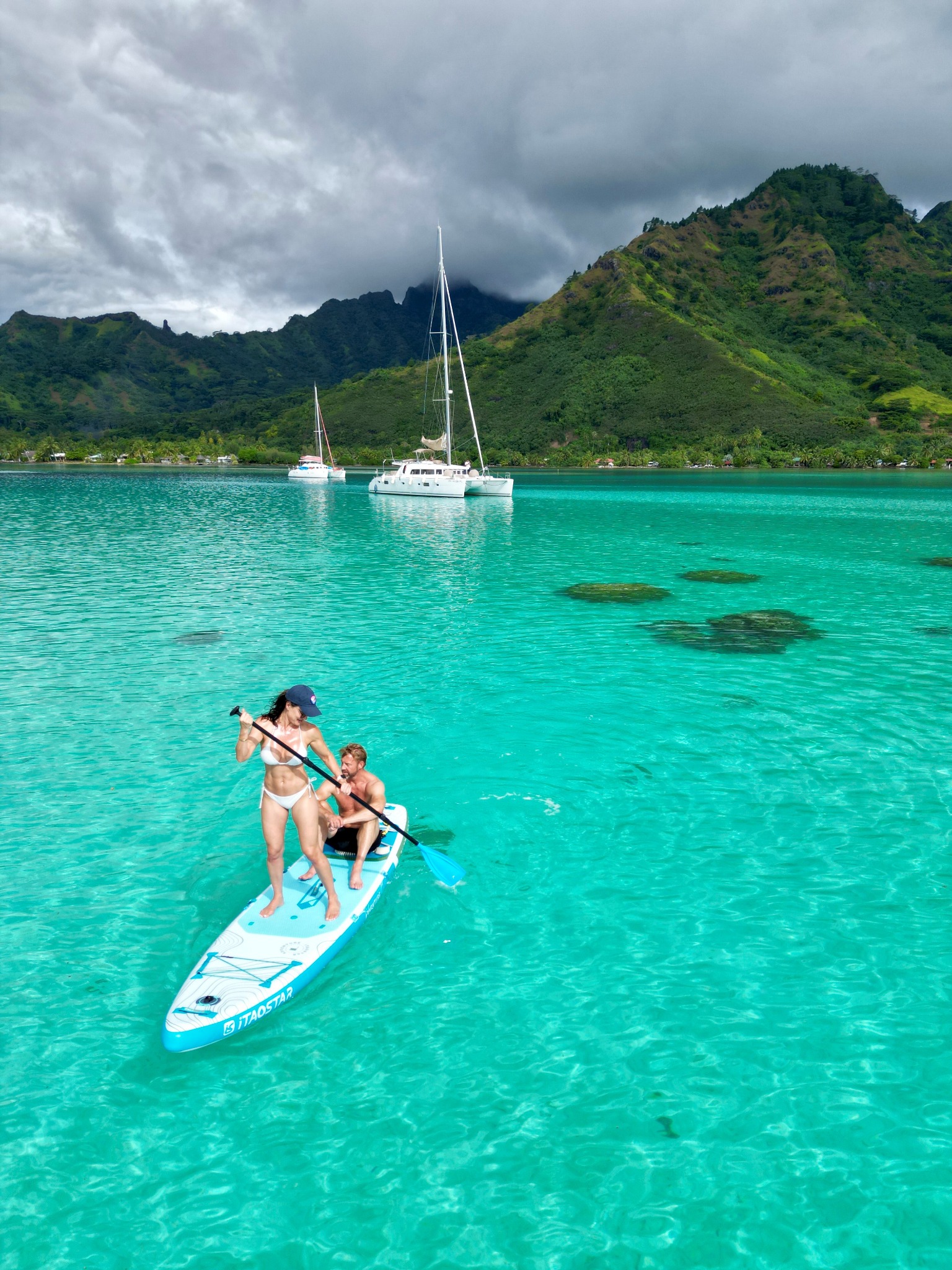 Paddle dans les eaux claires du lagon, avec des catamarans et les montagnes de Moorea en arrière-plan