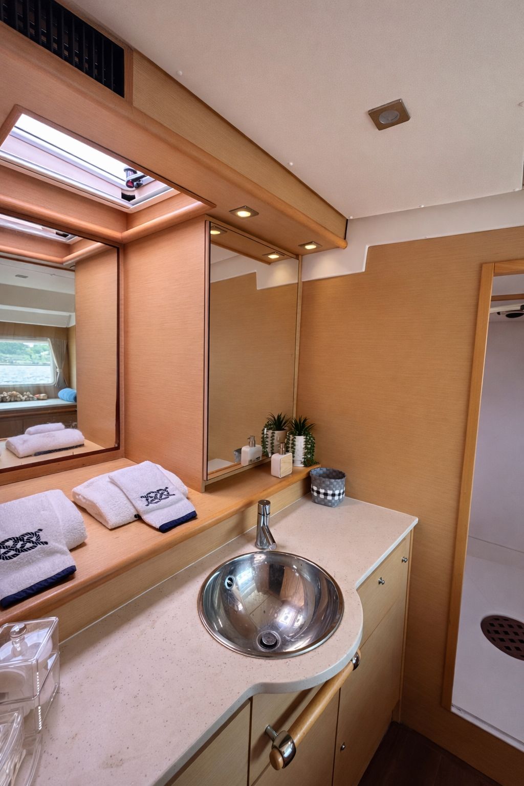 Salle d’eau à bord avec lavabo, miroirs et serviettes propres